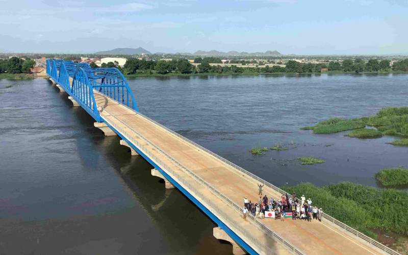 S laskavým svolením japonské agentury pro mezinárodní spolupráci (JICA) Zaměstnanci z Jižního Súdánu a Japonska oslavují dokončení mostu svobody přes řeku Nil v Jubě
