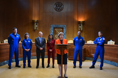 Zleva doprava: Shaheen a Moran se setkávají s astronauty Artemis II spolu s administrátorem NASA Billem Nelsonem a prezidentkou Kanadské vesmírné agentury Lisou Campbellovou; Shaheen pronáší poznámky