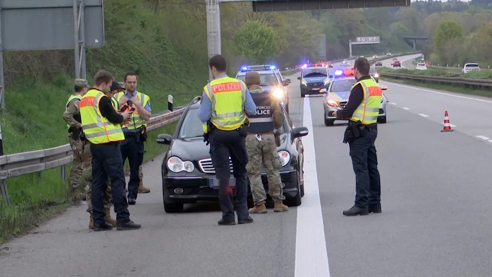 Němečtí a američtí policisté stojí společně na krajnici dálnice A6 poblíž Německého Homburgu (Sársko)